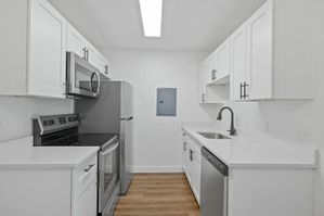 Modern kitchen with sleek stainless steel appliances, white cabinetry, and elegant countertops, offering a stylish and functional space for cooking.