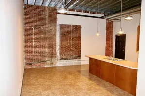 Chic loft-style space featuring exposed brick walls, industrial lighting, and a modern kitchen island with sink.