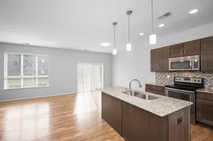 Modern open-concept kitchen with sleek granite countertops, stainless steel appliances, and large windows providing ample natural light.