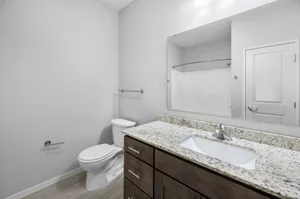 Modern bathroom with granite countertop, sleek fixtures, and elegant neutral tones for a sophisticated feel.