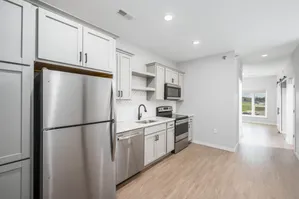Modern kitchen with stainless steel appliances, elegant cabinetry, and a bright window view in a stylish apartment.