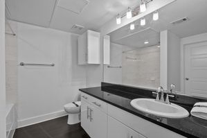 Elegant bathroom featuring a sleek black countertop, modern lighting, and spacious cabinets, offering a luxurious and functional design.