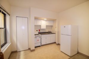 Bright, compact kitchen with modern appliances and ample storage space, featuring a large window for natural light.