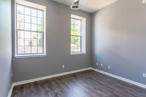 bedroom with wood floor and large windows