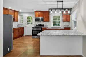 Modern kitchen with elegant granite countertops, sleek stainless steel appliances, and rich wooden cabinetry.