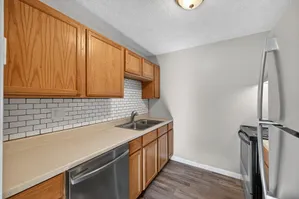 Modern kitchen with sleek stainless steel appliances, elegant wood cabinetry, and chic white subway tile backsplash.