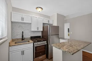 Modern kitchen with sleek granite countertops, stainless steel appliances, and elegant cabinetry, perfect for a stylish apartment.