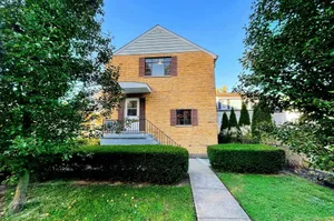 Charming living with a quaint front porch and lush green garden, ideal for cozy living.