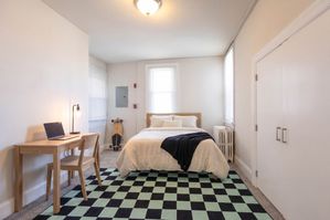 Bright and stylish bedroom featuring a cozy bed, modern desk, and elegant decor, complete with a trendy skateboard accent.