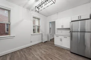Bright and modern kitchen with sleek stainless steel appliances, elegant white cabinetry, and stylish wood flooring.