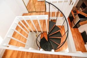 Elegant spiral staircase with sleek black steps, enhancing the modern interior charm.