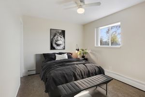 Bright bedroom with cozy double bed, stylish decor, and large window allowing natural light.