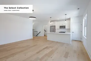 Contemporary open-concept kitchen and living area with sleek lighting and hardwood floors at Annex West Townhomes, part of The Select Collection.