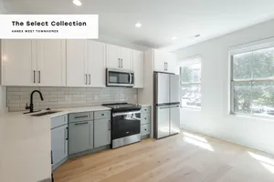 Bright modern kitchen in The Select Collection at Annex West Townhomes, featuring sleek cabinetry, stainless steel appliances, and large windows offering abundant natural light.