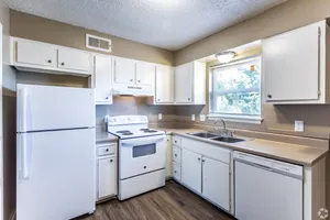 Kitchen with white cabinets and white appliances at Hunter Oaks Apartments in Memphis, TN