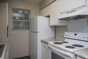 Kitchen with white appliances in 2 bedroom floor plan at Meadow Creek Apartments in Jackson, MS