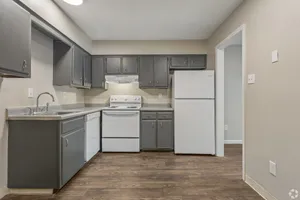 Kitchen with gray shaker cabinets and white appliances in a 2 bedroom townhome at Shadowbrook Townhomes in Memphis, TN