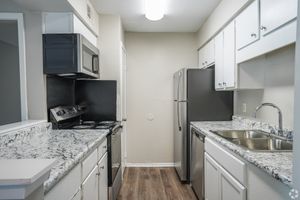 Kitchen with granite counters and black appliances in a 2 bedroom, 2 bath apartment at Trails at Northpointe in Jackson, MS
