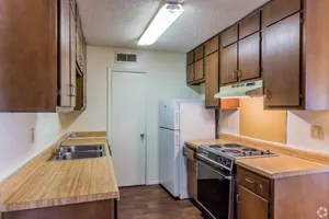 Kitchen with wood cabinets and black appliances at Hickory Pointe in Memphis, TN