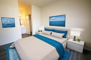 Staged bedroom with art on walls, bed and nighstands