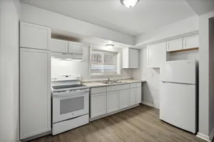 Modern kitchen with sleek white cabinets, spacious countertops, and stainless steel appliances, offering a bright and inviting cooking space.