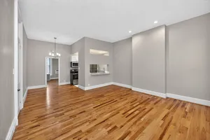 Spacious open-concept apartment with elegant hardwood flooring, modern lighting, and a stylish kitchen area.