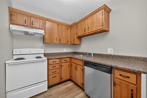 Charming kitchen with rustic wooden cabinets, modern appliances, and sleek countertops, perfect for culinary creativity.