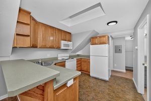 Charming kitchen with wooden cabinetry, modern appliances, and a cozy corner layout perfect for culinary creativity.