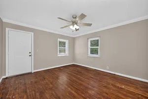 Inviting room with elegant hardwood floors, neutral walls, and abundant natural light, perfect for a cozy living space.