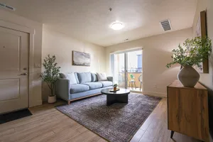 Inviting living room with a plush sofa, elegant coffee table, and access to a bright balcony.
