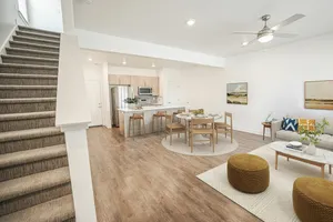 Inviting open-concept living space featuring a modern kitchen with bar stools, stylish dining area, and cozy lounge with contemporary decor.