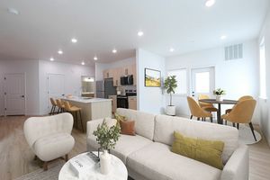 Modern open-concept living area with stylish kitchen island, cozy seating, and chic dining space with elegant light fixtures.
