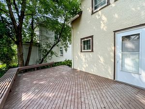 Charming outdoor deck with natural wood finish and lush green surroundings, perfect for relaxation and entertaining.