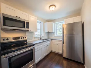 Contemporary kitchen with stainless steel appliances, sleek cabinetry, and elegant hardwood flooring.