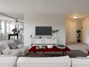 Chic living area with elegant modern decor, featuring a cozy white sofa, stylish red coffee table, and sleek entertainment unit.