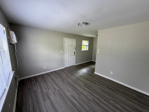 Bright and spacious living area with modern gray flooring and ample natural light, perfect for a comfortable home environment.