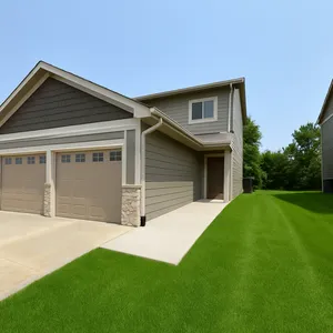 Charming two-story home with a double garage, modern siding, and a lush green lawn in a suburban setting.