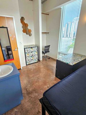 Contemporary apartment room with sleek furnishings, accent wall art, and abundant natural light through large windows.