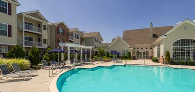 Inviting outdoor pool area surrounded by elegant apartment buildings with balconies, perfect for relaxation and leisure.