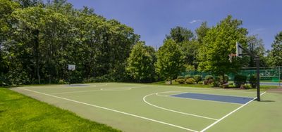 Serene outdoor basketball court surrounded by lush greenery, perfect for sports enthusiasts seeking a peaceful environment.