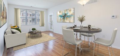 Elegant apartment living and dining area featuring chic modern furnishings, large windows with abundant natural light, and stylish wood flooring.