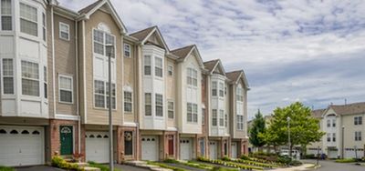 Charming townhouse row with elegant architecture and well-maintained landscaping in a peaceful neighborhood setting.