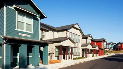 Charming neighborhood featuring colorful townhouses on a sunny street lined with well-maintained homes.