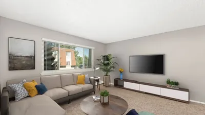 Inviting living room with cozy sectional sofa, modern decor, and large window offering natural light.