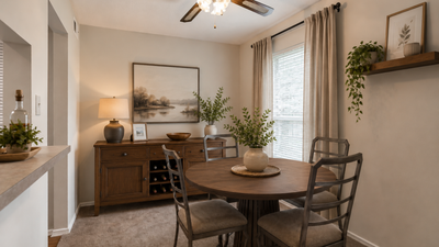 Elegant dining area with a rustic wooden table, chic chairs, and tasteful decor featuring lush greenery, creating an inviting atmosphere.