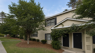 Charming suburban apartment with lush greenery and inviting walkway leading to a cozy two-story entrance.