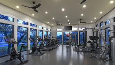 Modern fitness center with sleek design, featuring cardio equipment, weight machines, and large windows with scenic views.