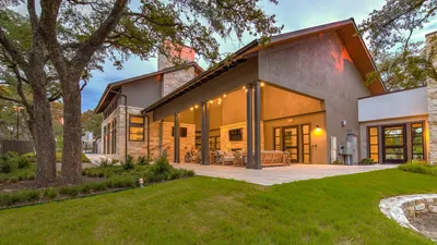 Charming outdoor patio with modern lighting and lush green lawn, perfect for relaxation and entertaining.
