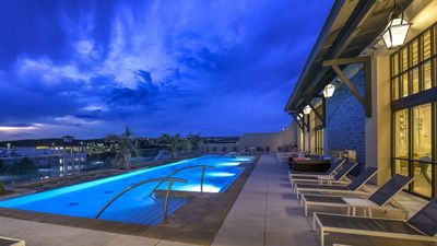 Elegant rooftop pool with modern lounge chairs and stunning evening sky view.