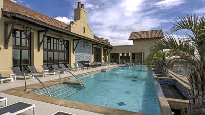Luxurious rooftop pool oasis with sleek lounge chairs and modern architecture under a clear blue sky.